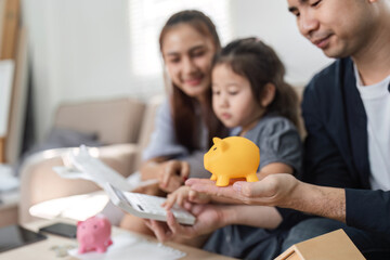 Family budgeting together with piggy banks, teaching children about saving money.