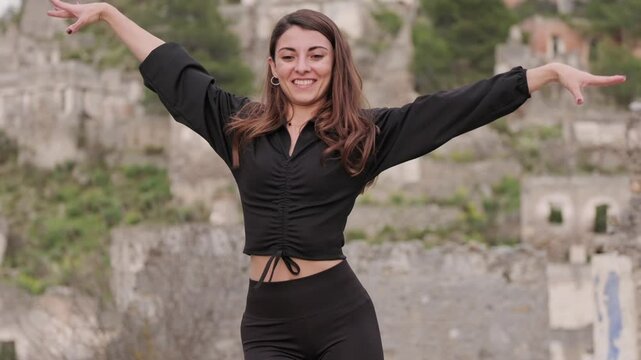 Smiling and dancing, she embraces the beauty of a historic and touristic location, where nature and ruins coexist in harmony.