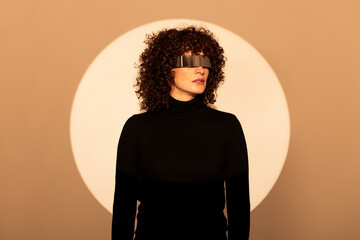 Woman wearing virtual reality simulator against beige background