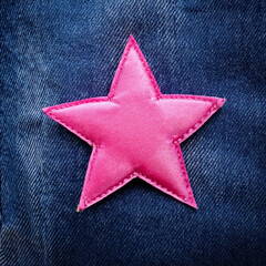 Close-up of a Pink Star Patch Sewn onto Blue Denim Fabric