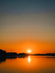 Naklejka premium A beautiful sunset over the sea. The setting sun over the sea. Hot air balloons taking off over the water at sunset.