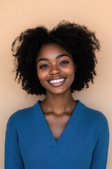 A cheerful young woman with natural curly hair and a bright smile, wearing a vibrant top.