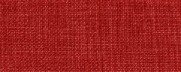 Fototapeta premium A textured fabric in a warm red hue, showcasing a woven pattern that adds depth and richness to the material.