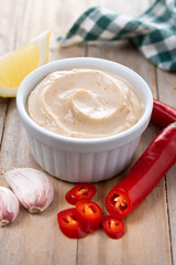 Chipotle sauce and spices in bowl on wooden table
