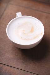 Cappuccino on dark wooden background. Soft focus. Close up.	