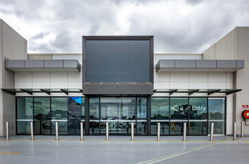 A modern commercial building or shopping mall entrance features a sleek, contemporary design. The...