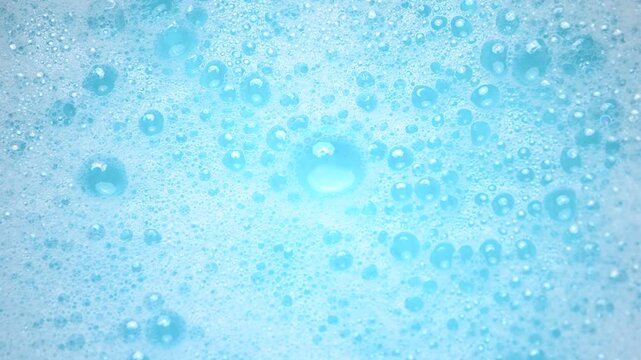 Soap suds in water, bubbles float and burst Abstract white soap foam texture. Concept of cleaning and washing.