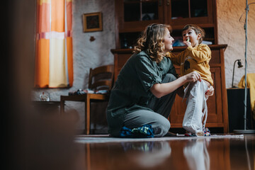 A cheerful young woman playing with a small child inside a warm, comfortably decorated home. This image captures a heartfelt and moving connection filled with love, care, and familial bonds.