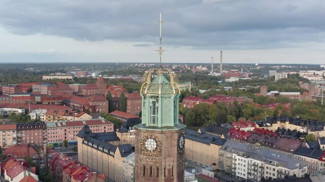 Engelbrektskyrkan in &Ouml;stermalm, Stockholm, Sweden during evening. Aerial shot rising while tilting downwards with top of church in foreground, skyline in background.