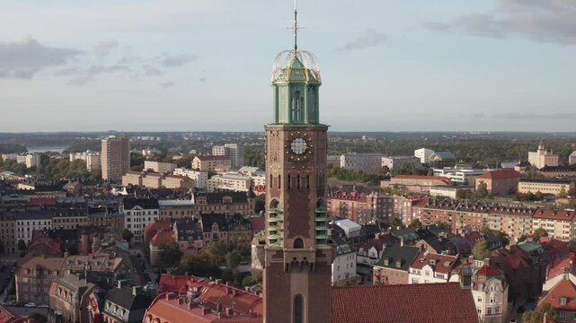 Engelbrektskyrkan in &Ouml;stermalm, Stockholm, Sweden during cloudy sunset in the summer. Aerial shot pushing away from the church showing skyline, buildings and rooftops.