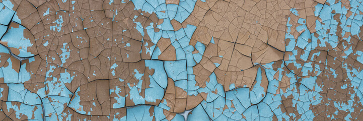 Peeling paint on the wall. Panorama of a concrete wall with old cracked flaking paint. Weathered rough painted surface with patterns of cracks and peeling. Wide panoramic grungy texture for background