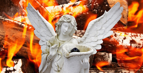 Statue of a guardian angel with wings on a background of fire. Mercy and suffering