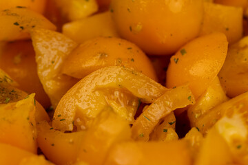 ripe orange tomatoes with spices cut into pieces of different sizes