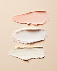 A beautifully arranged display of creamy makeup swatches in peach, white, and ivory on a soft beige background, highlighting luxurious textures and perfect for beauty product promotion