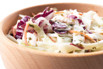 Coleslaw salad in wooden bowl isolated on white background. Close up