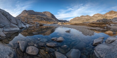 A tranquil, crystal clear lake nestled in a mountainous wilderness with reflections of the peaks.