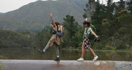 Friends, women and hiking with balance while walking, bridge and lake with travel together....