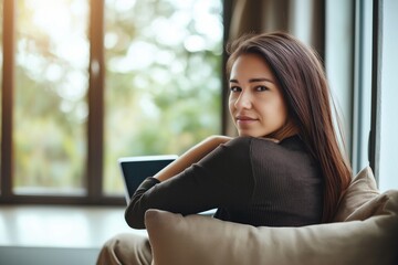 Fototapeta premium Focused woman working on a laptop in a cozy forest cabin surrounded by trees and natural light creating a peaceful working environment