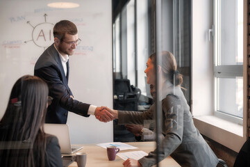Business professionals shaking hands during a meeting in a modern office. Concept of partnership,...