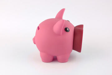 The pink piggy bank and dollars on white table.