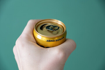 hand holding a zero sugar soda can.