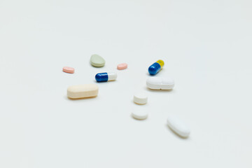 colored pills and capsule on white background