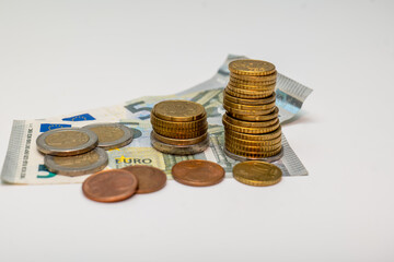Five euro banknotes, cash paper money and coins isolated on white background