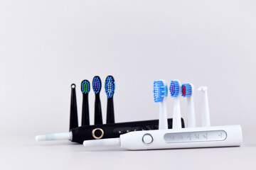 Modern electric ultrasonic toothbrush with rechargeable battery on a gray surface.