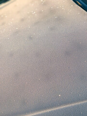 Close-up of a car hood with delicate frost patterns.