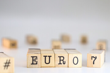 The word euro 7 written on wooden cubes on a white background with space for text. Concept of European standards