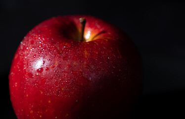 Close up of fresh red apple on a dark background with copy space. Still life