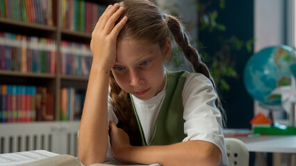 Suffering tired upset Caucasian little girl sad schoolgirl child school kid pupil learner student reading difficult task thinking hit her head hard homework schoolwork exam cognition problem indoors