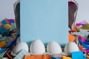 Easter eggs on a blank card surrounded by colorful festive confetti decorations