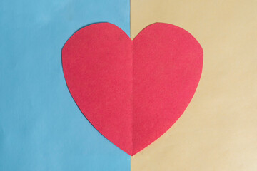 Valentines day concept. The red paper heart on a blue and yellow background.