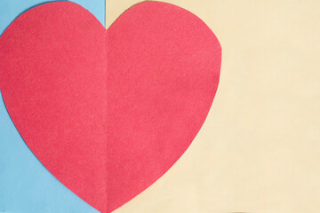 Valentine's Day concept. Red paper heart on a blue and yellow background.