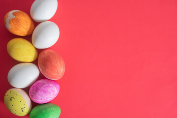 Obraz premium Colorful Easter eggs arranged on a vibrant red background. Top view
