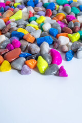Multi-colored stones on a white surface for decoration.