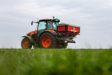Tractor spreading artificial fertilizers in field