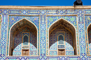 Obraz premium Part of Registan Square in Samarkand, Uzbekistan, a historic architectural ensemble featuring three stunning madrasas with intricate mosaic designs, domes, and minarets under a bright blue sky