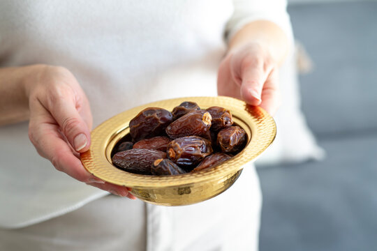 Woman with bowl of tasty sweet dried dates. Happy Ramadan Kareem