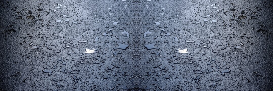 Des petites flaques d'eau sur le bitume, avec effet sym&eacute;trique