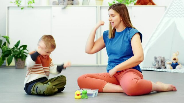 Baby Sign Language. Nonverbal child learning to sign with the help of a speech therapist. Child therapy, neurodiversity, learning difficulty, developmental disability.