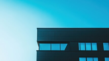 Obraz premium A minimalist masterpiece, a modern architectural marvel, stands as a stark silhouette against the backdrop of a clear, azure sky, showcasing the harmonious interplay between form and function.