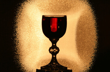 Cup of Light. A glass of red wine illuminated by a warm golden light.