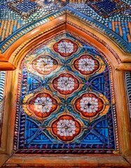 A macro shot of a colorful tile mosaic on a historic building, showcasing intricate symmetrical patterns and vibrant colors, highlighting the craftsmanship and historical artistry.