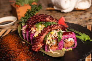 Sushi roll decorated with octopus on top, delicious Japanese food to share, special Japanese food dish