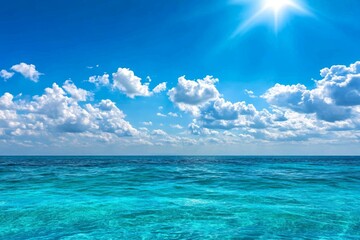 Obraz premium A serene ocean scene with the sun shining through clouds, casting rays of light on the calm waters. The sky is blue and white, creating an atmosphere of tranquility and peace. In front of it