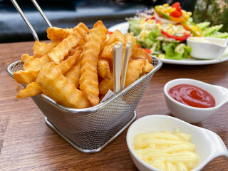 French fries in a basket, served with ketchup and mayonnaise