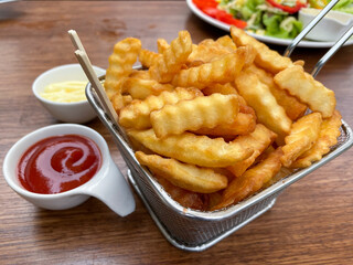 French fries in a basket, served with ketchup and mayonnaise