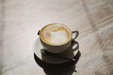 White classic cup with coffee and foam. Delicious natural coffee. Morning invigorating drink.